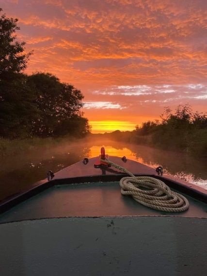 Narrow boat on the river at sunset